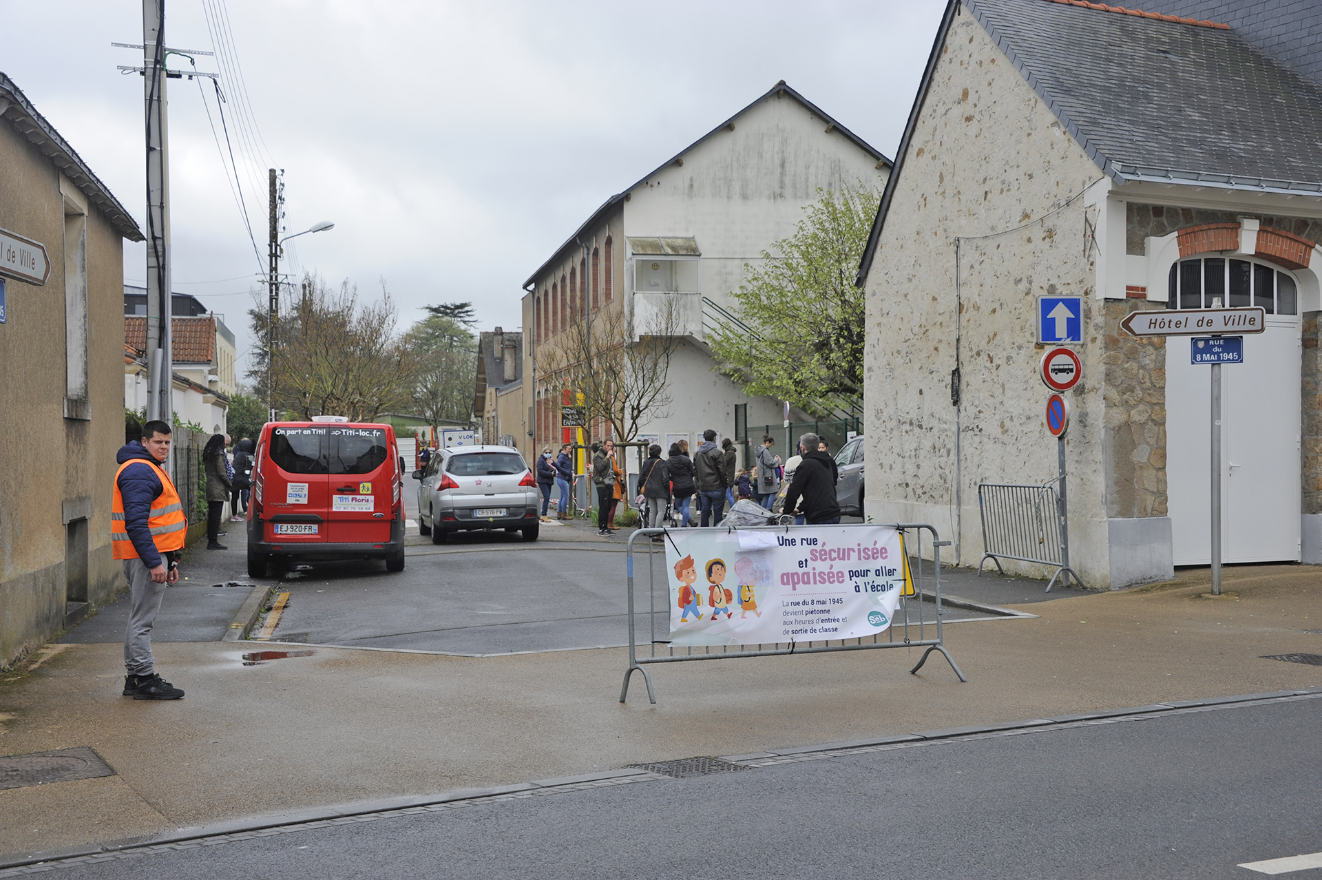 Barrière et gardien dans une rue d'école à l'heure de rentrée et sortie des écoliers